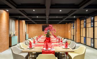 a large , well - decorated dining room with long tables covered in red and white tablecloths , creating a festive atmosphere at Ibis Styles Bekasi Jatibening