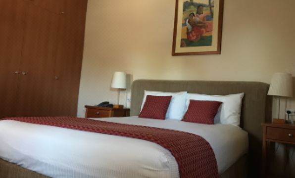 a neatly made bed with a red and white blanket is shown in a hotel room at Comfort Inn & Suites Sombrero