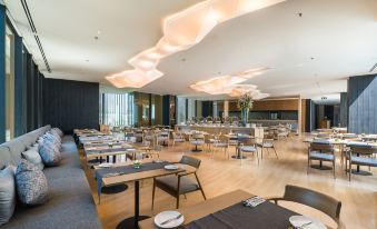 a large dining room with multiple tables and chairs arranged for a group of people to enjoy a meal together at Arize Hotel Sri Racha