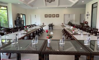 a large dining room with multiple long tables and chairs arranged for a group of people to enjoy a meal together at Content Villa Chiangmai