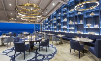 a modern restaurant with blue walls , gold ceiling , and blue tables , along with other dining area furniture at Vila Vita Parc