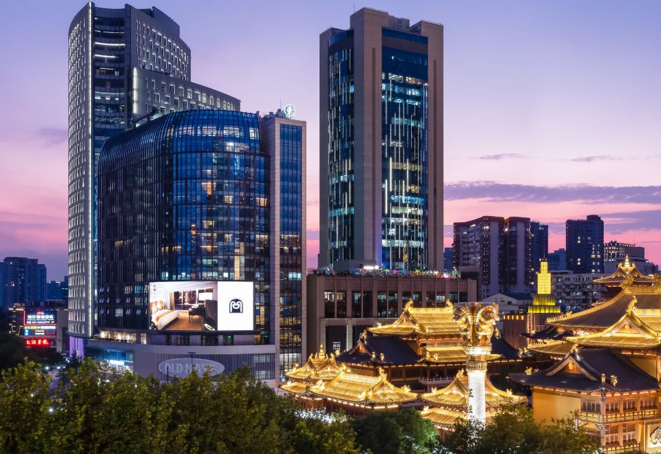 A city at night with a lit skyline and illuminated buildings on either side creates a stunning and lively scene at Paramount Gallery Hotel