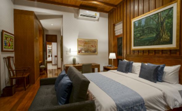 a spacious bedroom with a large bed , a couch , and a painting on the wall at Mae Rim Grace