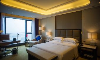 In the middle room, there is a large bed with windows and a sitting area adjacent to it at KinDream Hotel