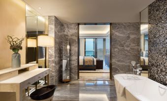 a luxurious bathroom with a large mirror , a bathtub , and a view of the ocean at Sanya Xizang Hotel