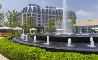 a large fountain with multiple jets shooting water into the air in front of a building at Sheraton Qinhuangdao Beidaihe  Hotel