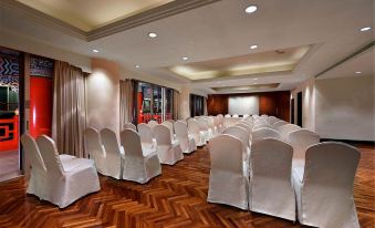 A spacious ballroom is arranged with tables and chairs for an event at The Grand Hotel