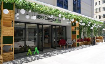 In front of the store, there is an entrance with chairs and tables, as well as outdoor seating alongside it at Campanile Hotel (Shanghai Railway Station, People's Square)