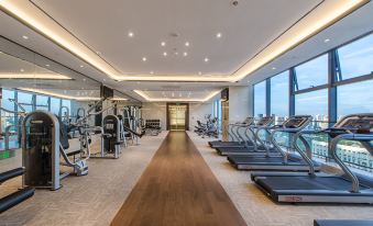 There is a spacious room with multiple exercise machines and a central indoor gym area at Orchid Sea Hotel