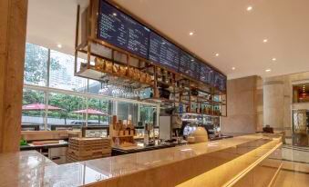 restaurant with a menu displayed on the wall above large windows, adjacent to an open area at Asia International Hotel