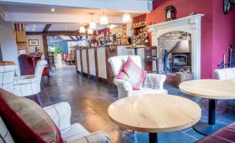 a cozy and well - decorated restaurant with various seating options , including couches , chairs , and a dining table at The Nags Head