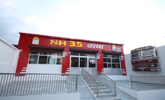 "a red and white building with the sign "" nh 3 5 dhaba "" on it , located in a town" at The Retreat
