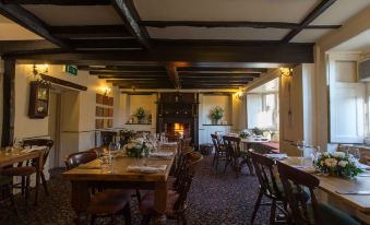 a dining room with wooden tables and chairs arranged for a group of people to enjoy a meal together at Bartholomew Arms