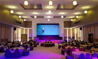 a large room with multiple tables and chairs set up for a formal event , possibly a wedding or conference at Hotel Grand Baron