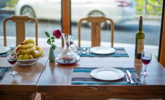 There is a table with plates, bowls, and glasses, as well as an empty vase, placed on it at Manyuan Resort Hotel