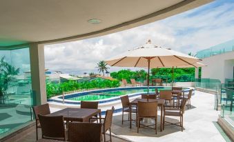 an outdoor dining area with several tables and chairs , as well as a pool in the background at Star Hotel