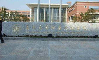 The entrance to a city is marked by an ornate building with a sign on top at Motai Hotel (Shanghai Hongqiao International Exhibition Center Jiuxing)