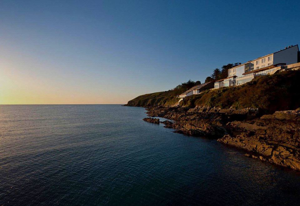 a large body of water , possibly an ocean or a lake , with a group of people standing on the shore at Cliff House Hotel