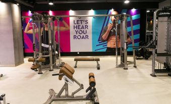 "a gym with a large sign that says "" let 's hear you roar "" and several people exercising on it" at Palm Seremban Hotel