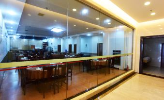A modern dining area with tables and chairs can be seen through a glass wall in a spacious room at Kaiserdom Hotel (Guangzhou Baiyun Airport)