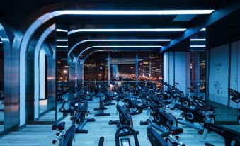 A room with multiple rows of items on the floor, including an exercise bike positioned in the front at Jen Beijing by Shangri-La