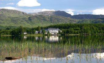 a serene lake surrounded by lush green trees , with a white building in the background at Harvey's Point