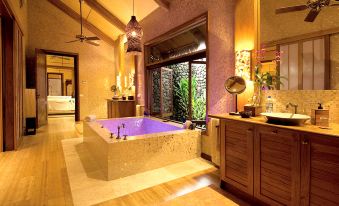 a luxurious bathroom with a large bathtub surrounded by windows , allowing natural light to fill the space at The Wakaya Club & Spa