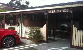 "a small building with a sign that reads "" beer garden "" on it , located in a parking lot" at Econo Lodge Lilydale
