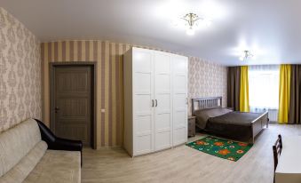 a room with a wooden floor , white wardrobe , and black bed in front of a window at Vernisage