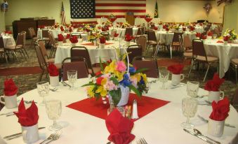 a dining room set up for a party , with tables covered in white tablecloths and decorated with flowers at Gateway Hotel