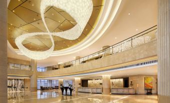The hotel lobby is elegantly designed with a large chandelier in each room at Tianyuan Hotel