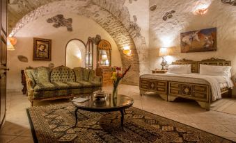 a living room with a couch , ottoman , and coffee table in front of an arched doorway at Hacienda San Gabriel de las Palmas