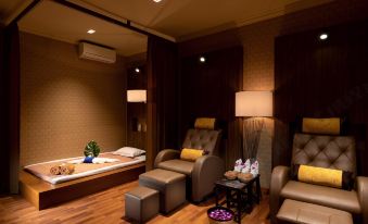 a cozy living room with comfortable seating , a bathtub , and a tray of flowers on the floor at Grand Palace Hotel