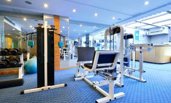 A spacious room with multiple exercise equipment, including an indoor weight machine positioned in the center at Beijing Xinqiao Hotel