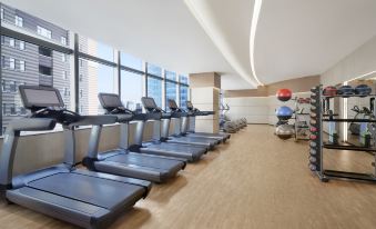 The gym is equipped with large windows and an indoor exercise room in the middle at Shanghai Marriott Marquis City Centre