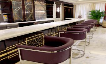 A communal space featuring tables, chairs, an open concept kitchen with a bar counter and cooking appliances is provided for guests to dine and socialize at Metropolo Xin Cheng Hotel, The Bund Shanghai