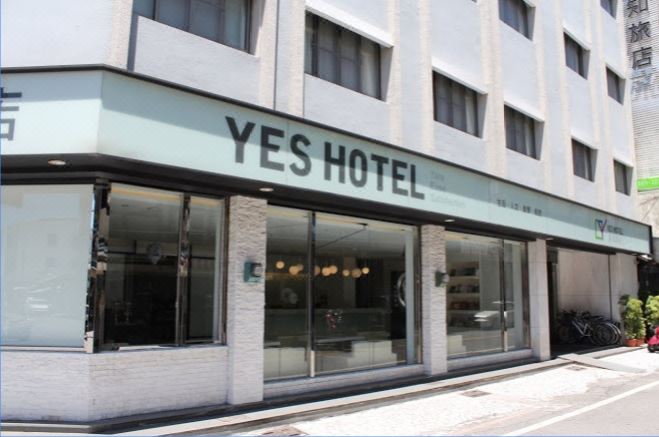 "a building with a sign that reads "" yes hotel "" prominently displayed on the front of the building" at Yes Hotel