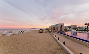 a beautiful beach scene with a large pool surrounded by several buildings , creating a picturesque atmosphere at Banyan Tree Tamouda Bay