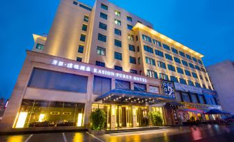 The illuminated building behind the hotel creates a striking front view at night at Kasion Purey Hotel (Yiwu International Trade City store)