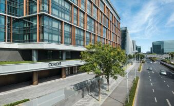 A large building with a view of the street, which is lined with tall buildings at Cordis Shanghai Hongqiao