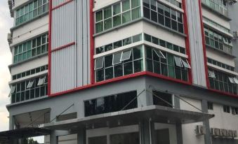 a large building with a red and white color scheme , located in a city setting at My Inn Hotel Kota Samarahan