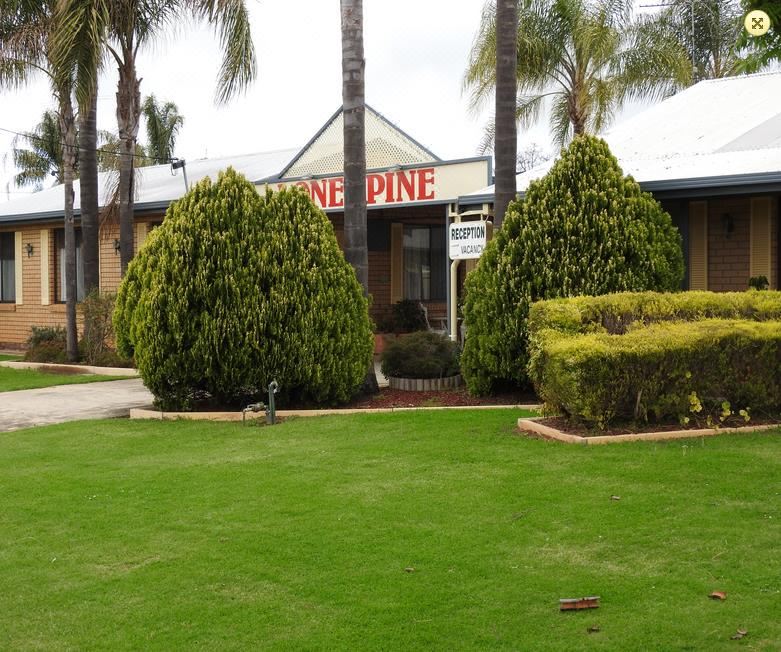 "a brick building with a sign that reads "" cafe pine "" prominently displayed on the front of the building" at Lone Pine Motel