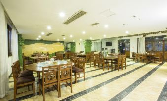 a large dining room with wooden tables and chairs arranged for a group of people to enjoy a meal together at Panda Hotel