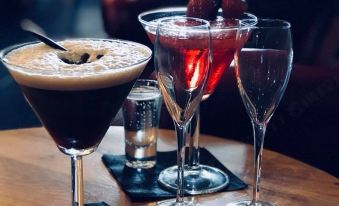 a dining table with three glasses of drinks , including a martini and two cocktails , placed on it at The Nags Head