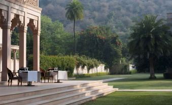 The patio, located on the side, offers a view of an outdoor seating area and is furnished with chairs and tables at Amanbagh