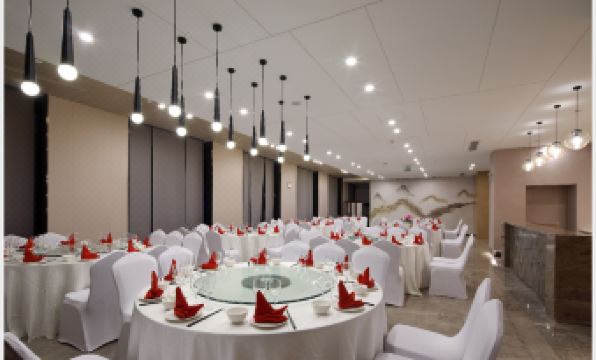 A room is prepared with tables and chairs for an event at a hotel or conference venue at Jinfan Wanyuan Hotel
