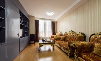 A spacious room with hardwood floors and furniture, including couches and chairs in the living area at Mankedun Hotel (Guangzhou Sanyuanli Metro Station)
