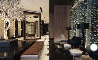 The room is accompanied by a lobby featuring two chairs, tables, and an aquarium at Jen Beijing by Shangri-La