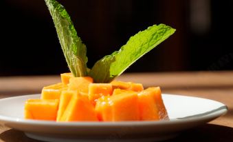 a plate of sliced carrots on a dining table , accompanied by a mint leaf and a knife at Hotel Sabana Park