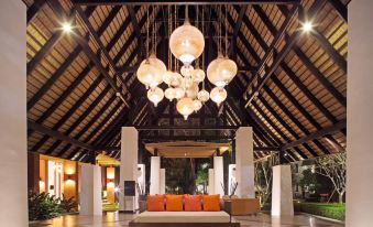 a spacious hotel lobby with an open floor plan , wooden beams , and large hanging lights at Mida Resort Kanchanaburi